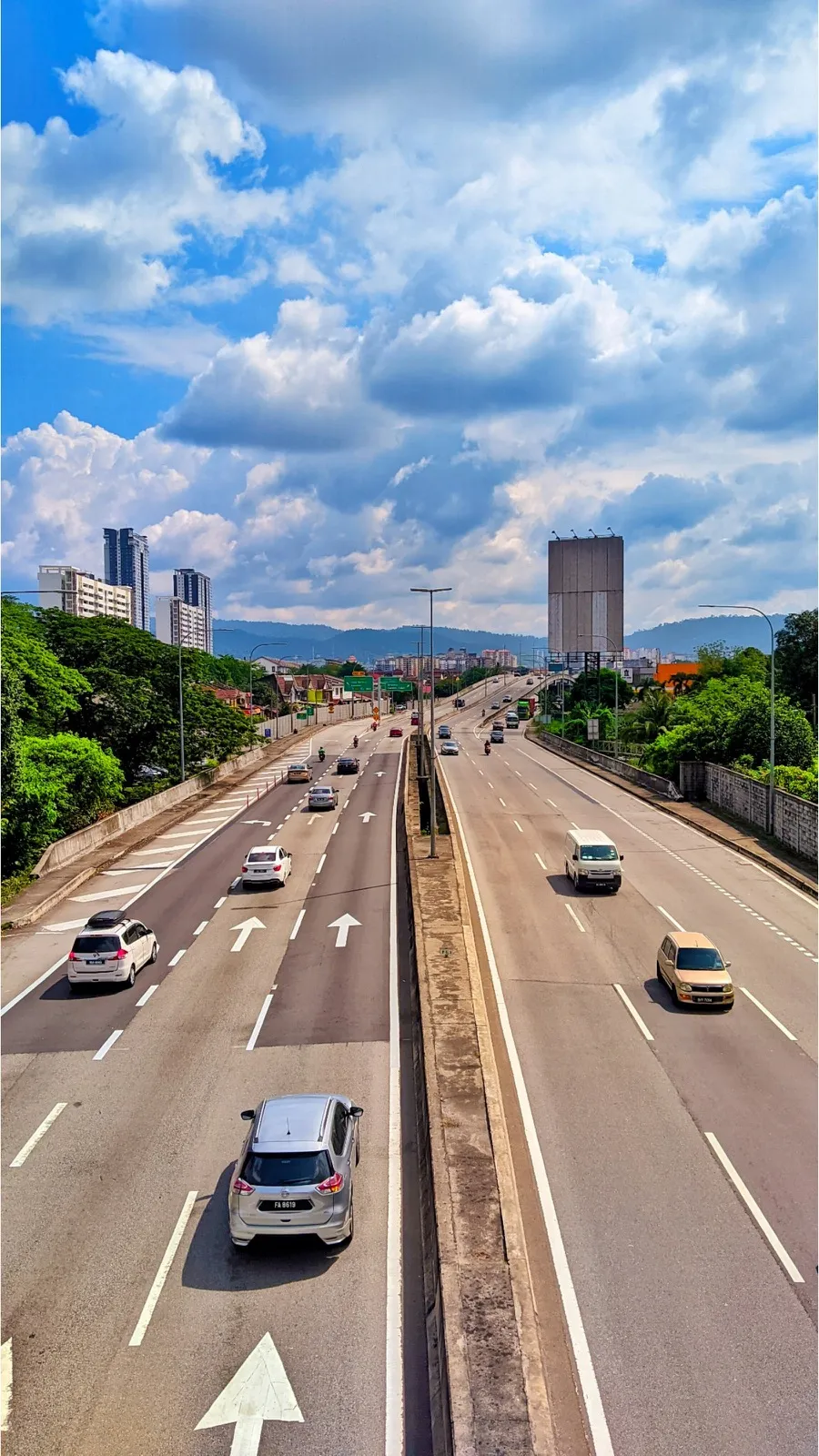 A Malaysian highway with lane arrows painted on the road.